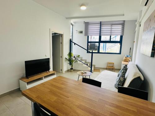 een woonkamer met een tafel en een bank bij Casa Sofia - Costa Calma Sun & Beach in Costa Calma