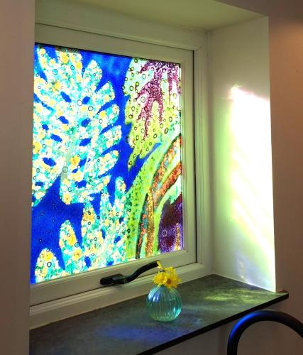 a window with a glass vase sitting on a counter at Ty Heulwen Studio in St. Davids