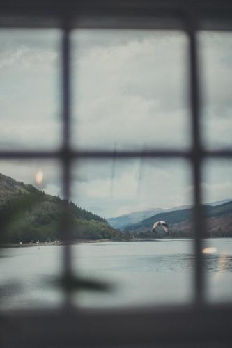 a view of a lake through a window at NICHT' Apartments Inveraray Town Centre in Inveraray