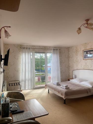 a bedroom with a bed and a large window at Pensjonat Wioletta in Ostrołęka