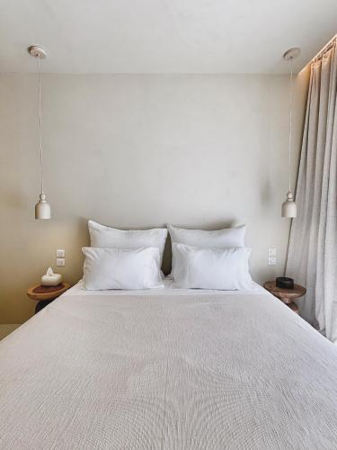 a bedroom with a large white bed with white pillows at âme casa in Mesochórion