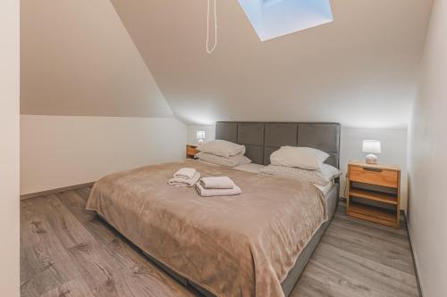 a bedroom with a bed with two towels on it at Moderní podkrovní byt 2KK u náměstí s klimatizací in Hradec Králové