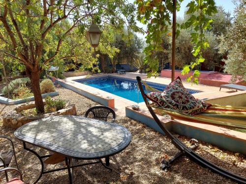 a table and a bench next to a swimming pool at Aguas Calmas in Nigüelas