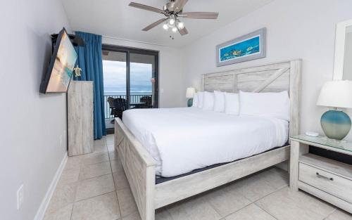 Phoenix X 1412 condo في شاطئ أورانج: غرفة نوم بها سرير أبيض كبير ونافذة