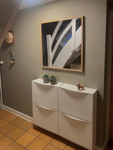 a white dresser with a picture on the wall at True Skagen House From 1870 By The West Coast in Skagen