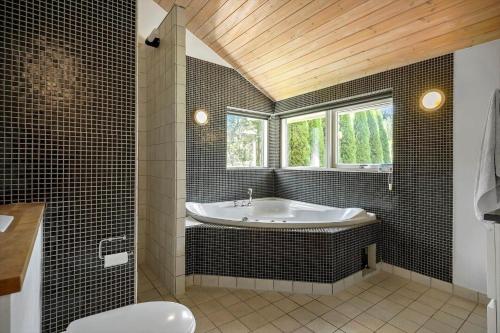 a bathroom with a tub and a window at K19089-Kalundborg-Granlygardsvej-30 in Ågerup