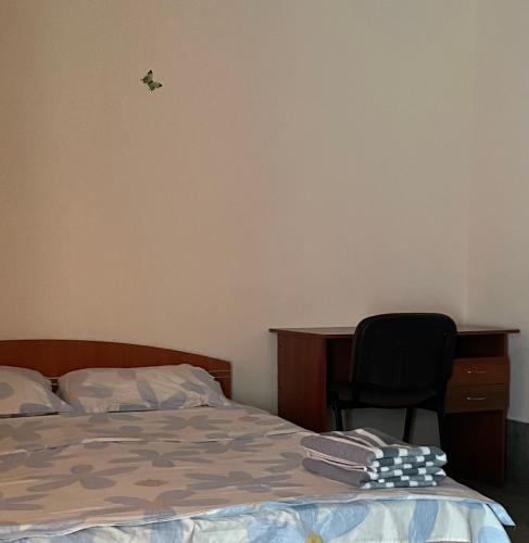a bedroom with a bed and a desk and a chair at Tima Hotel Chisinau in Chişinău