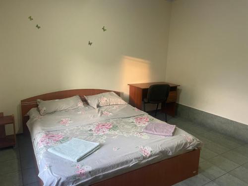 a bed in a room with a desk and a bed at Tima Hotel Chisinau in Chişinău