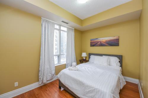 a bedroom with a bed and a window at PlanURstay - Ideal 2BR & 2 BTH - Near SQ1 Mall in Mississauga