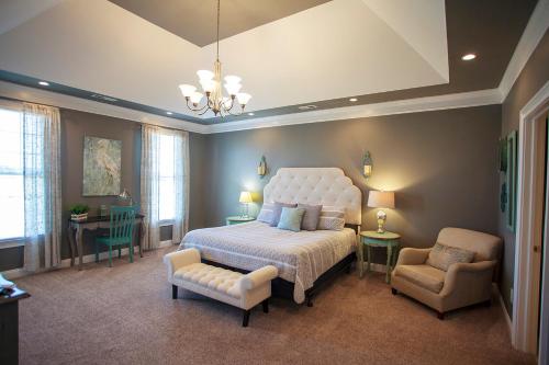 a bedroom with a large bed and a chair at The Inn, Occano Arnold Palmer Golf, Luxury 4 Bedroom 