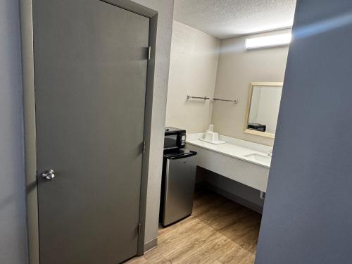 a bathroom with a sink and a toilet and a mirror at Days Inn by Wyndham Lake City I-10 in Lake City