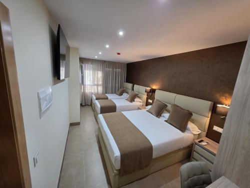 NoveléにあるAgora Hostalのベッド2台とテレビがあるホテルの部屋