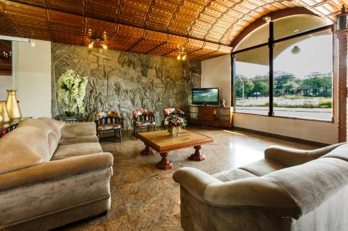 sala de estar con 2 sofás y TV en Mirante Hotel, en Foz do Iguaçu