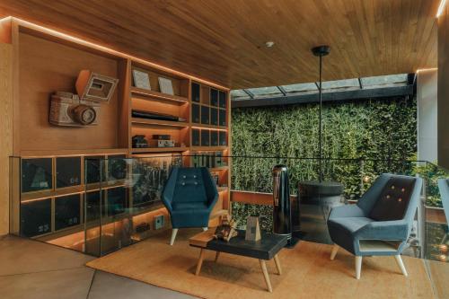 uma sala de estar com duas cadeiras e uma mesa em The Click Clack Hotel Bogotá em Bogotá