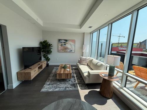 a living room with a couch and a flat screen tv at Downtown Bright & Vibrant 1 BR with huge patio in Halifax