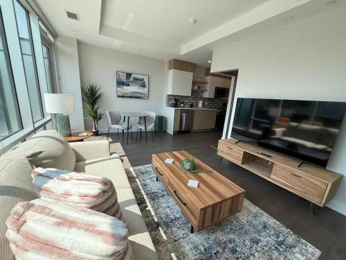 a living room with a couch and a large television at Downtown Bright & Vibrant 1 BR with huge patio in Halifax