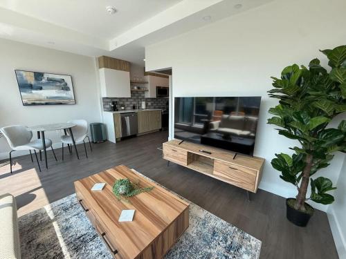 a living room with a coffee table and a tv at Downtown Bright & Vibrant 1 BR with huge patio in Halifax