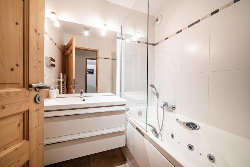 une salle de bain avec une baignoire, un lavabo et une douche dans l'établissement Le Cristal 2, aux Gets