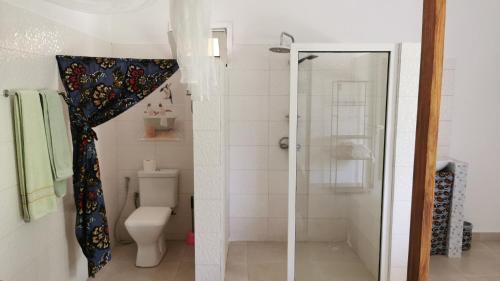 a bathroom with a shower and a toilet with a shower curtain at Chambre a cap skirring avec acces piscine in Cap Skirring
