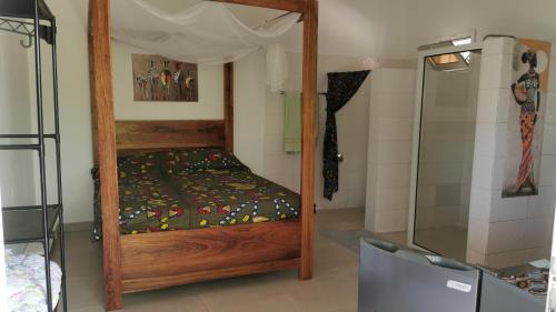 a bedroom with a canopy bed and a shower at Chambre a cap skirring avec acces piscine in Cap Skirring