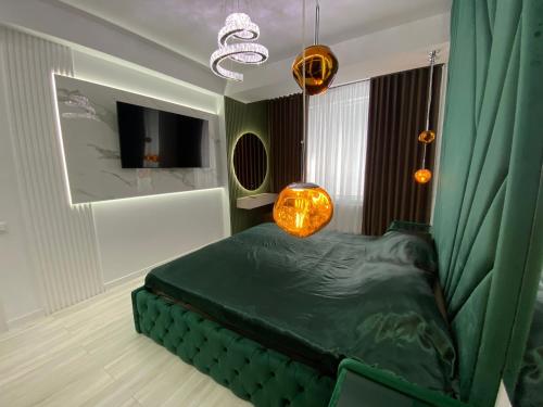 Oasis في كيشيناو: غرفة بها سرير أخضر وجهاز تلفزيون