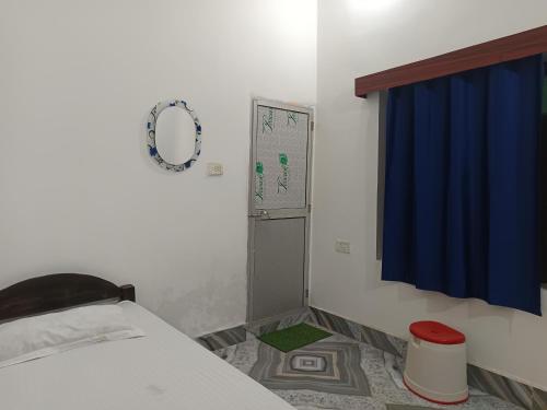 a bedroom with a bed and a blue curtain at Shahi House in Bodh Gaya