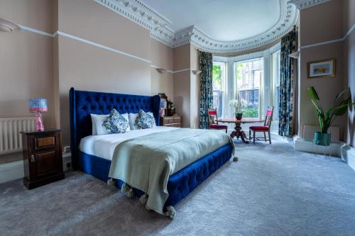 a bedroom with a blue bed and a table at Rooms & Apartments Malone Road in Belfast