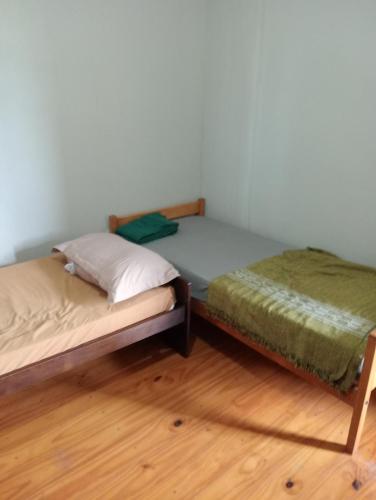 due letti singoli in una stanza con pavimenti in legno di Rincón de Santa Tecla a Puerto Valle