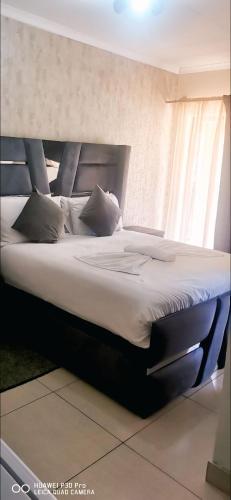 een slaapkamer met een groot bed met witte lakens en kussens bij SUNFLOWER bed and breakfast in Ladysmith