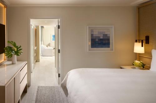 a bedroom with a white bed and a hallway at Loews Miami Beach Hotel in Miami Beach