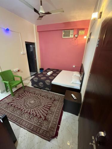 古瓦哈提Hemalata Hilltop Residency Kamakhya的房间里有两张床、一把绿色椅子和一块地毯。