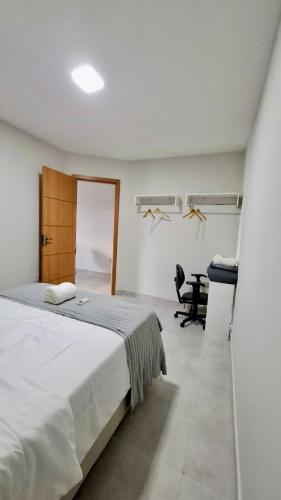 een witte slaapkamer met een bed en een bureau bij Apartamento Completo aconchegante- Fácil acesso ao Aeroporto e a COP-30 in Belém