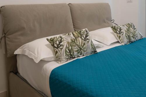 a bed with white and blue sheets and pillows at Suite Malu in Naples