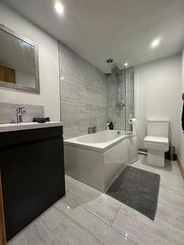 a bathroom with a tub and a sink and a toilet at Tranquil detached barn in Sherborne St John in Sherborne Saint John