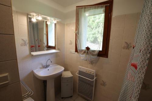 a bathroom with a sink and a toilet and a window at Salatua in Musculdy