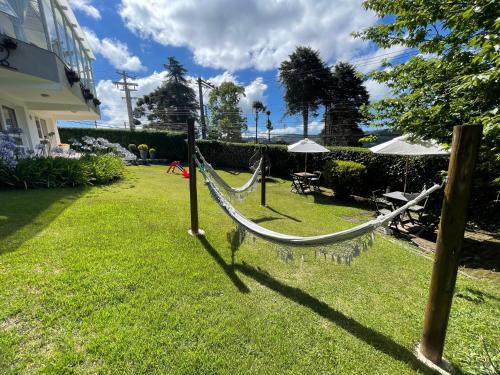a hammock in the yard of a house at Vila de Charme Suítes in Campos do Jordão