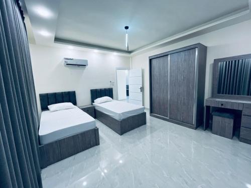 a bedroom with two beds and a fireplace at Zurich Furnished Apartments in Al Mafraq