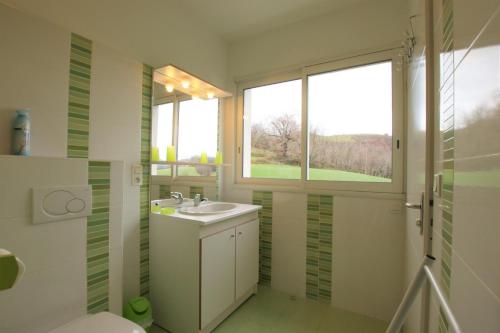 Un baño con lavabo, inodoro y ventana. en Lur-xuri-bidean, en Louhossoa