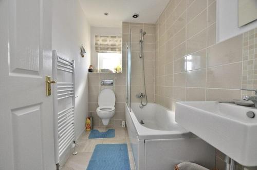 a bathroom with a toilet and a sink and a tub at Seaside-Retreat in Largs