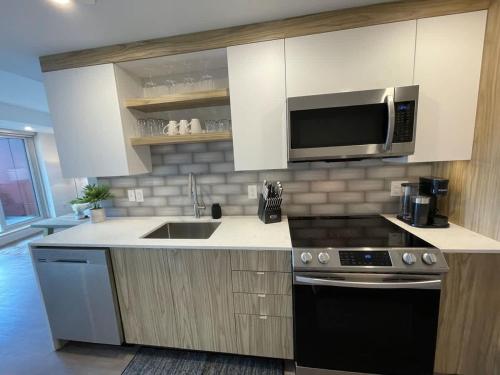 a kitchen with white cabinets and a microwave and a stove at Bright bold & beautiful 1 BR with 6 applainces in Halifax