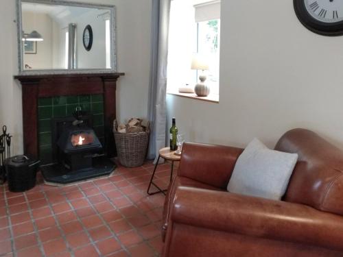 een woonkamer met een bank en een open haard bij The Smiddy in Glasserton
