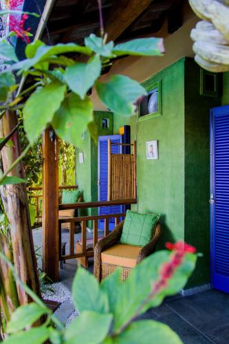 a living room with a chair and a balcony at Pousada DiMari in Boicucanga