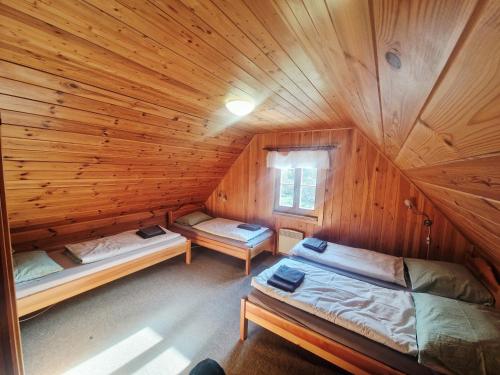 um quarto com duas camas em uma cabana de madeira em Chalupa Pod lomem - Malá em Dolní Morava