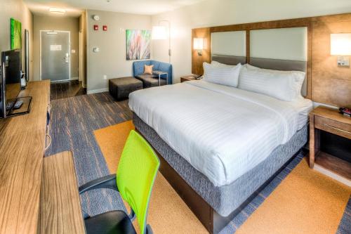 a hotel room with a large bed and a chair at Holiday Inn Express & Suites Cleveland/Westlake by IHG in Westlake