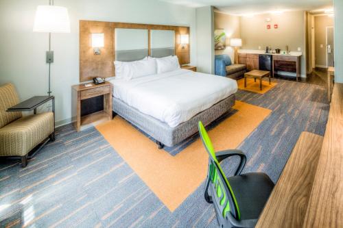 a hotel room with a bed and a chair at Holiday Inn Express & Suites Cleveland/Westlake by IHG in Westlake