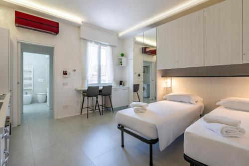 a hotel room with two beds and a bathroom at Harmony's Nest - Vicino a treno e Fiera Milano in Rho