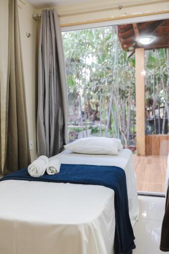 a bed with towels on it in a room with a window at Pousada Boa Vista in Barreirinhas