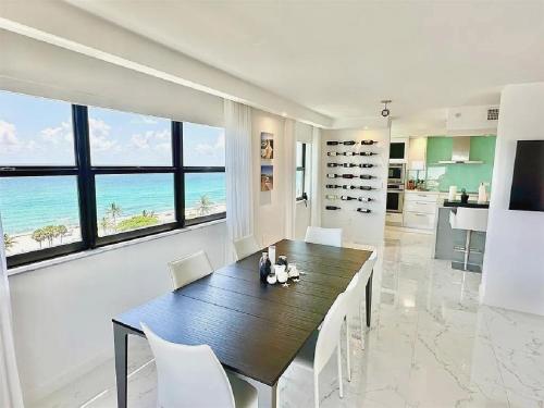 a dining room with a table and a view of the ocean at Luxurious Three-Bedroom Oceanfront Apartment with Private Balcony in Hollywood Beach