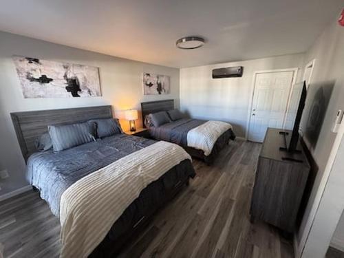 a bedroom with two beds and a television in it at Empire Extended Stay in Webster