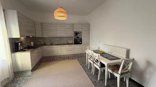 une cuisine avec une table et des chaises dans une pièce dans l'établissement Villa Pietra Sardinia - Luxury 165 m2 Historic Stone House with Fireplace and Rooftop, à Tempio Pausania